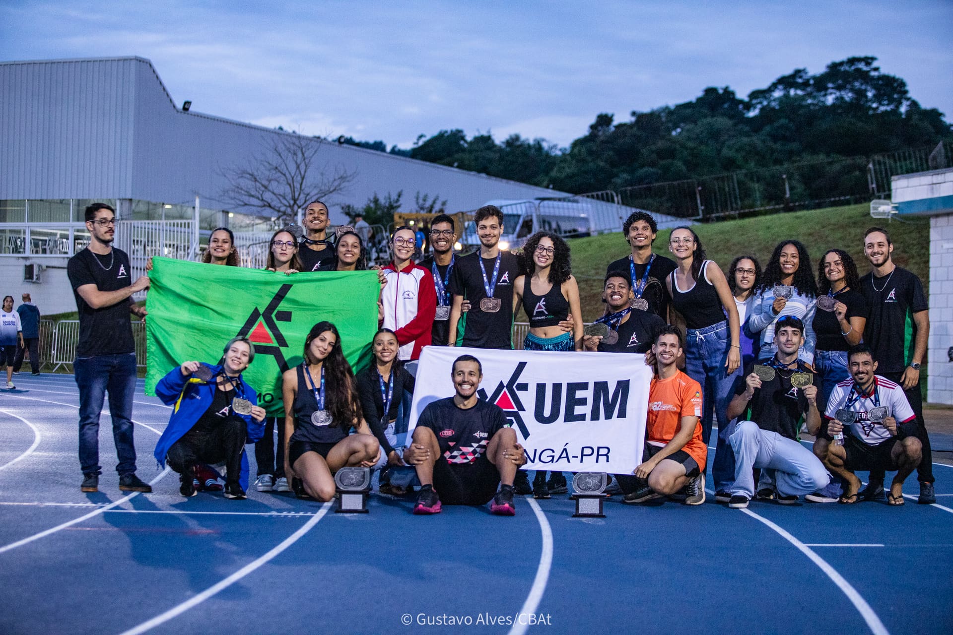 Equipe do Atletismo UEM comemorando com medalhas e troféus no Troféu Adhemar Ferreira da Silva 2025
